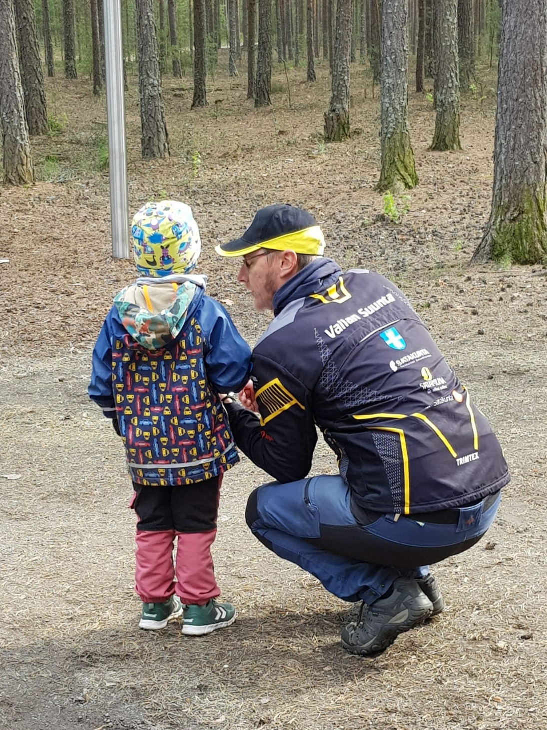 Joonas Pohjala opastaa lasta suunnistamaan